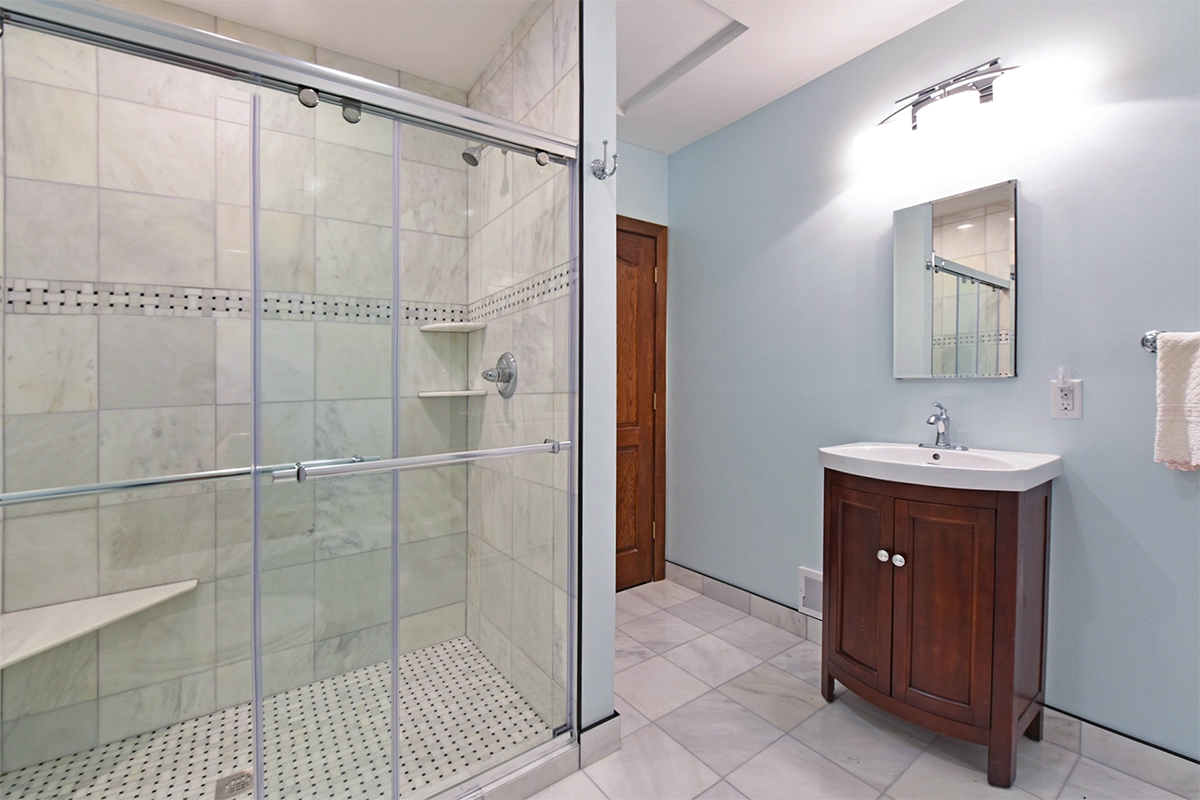 Historic Maple Grove MN bathroom renovation featuring a custom marble walk-in tile shower and matching tile flooring