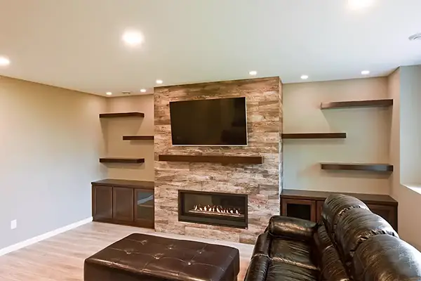 Basement finishing services featuring built-in fireplace and custom shelving in Blaine MN